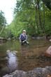 © goodluz - young woman fly fishing in a mountain river