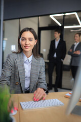 Business woman with her staff, people group in background at modern bright office indoors.