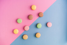 Studio Shot Of Pastel Colored Macaroon Cookies Flat Laid Against Pink And Blue Background
