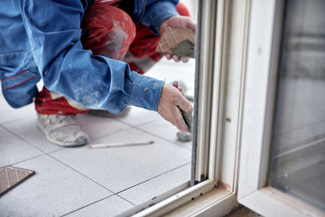 Wall Mural - Professional ceramics tile man worker placing new tiles on the floor and wall.