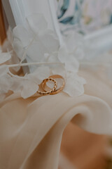 Wall Mural - Vertical closeup shot of gold wedding rings on a decorative bride table