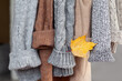 Pastel warm knitted clothes sweater hanging in the closet. Cozy autumn and winter wardrobe.
