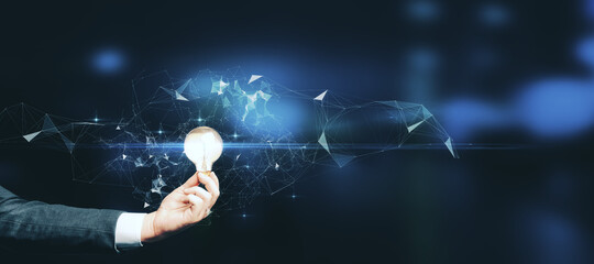 Poster - Close up of hand holding glowing polygonal light bulb on blurry blue background with mock up place. Idea and innovation concept.