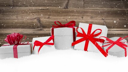 Wall Mural - Still life with gift row with red ribbons on snow covered surface. Wooden board in the background. Falling snow effect. Christmas, seasonal, holiday and winter concept. High quality 4k video.