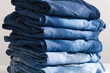 a pile of blue jeans on a light background. Sunlight. Close up