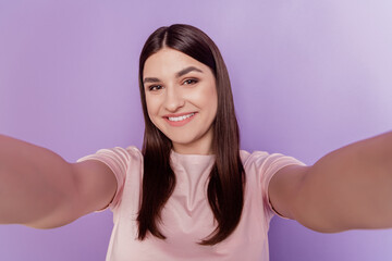 Wall Mural - Portrait of adorable sweet positive lady hold camera shoot selfie shiny smile on purple background