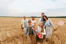 Happy Family Walking On Wheat Field