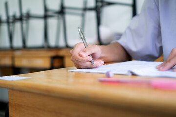 Wall Mural - Hand female Asian students taking exam test and concentration reading document exercise at classroom in high school. Teenager notes for SAT PISA measurement educational, back to school for evaluation