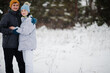 © AS Photo Family - Couple at winter day. Walking in the park on cold day with snow and snowfall.
