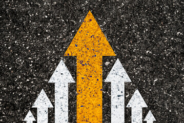 yellow big arrow move leading from small white arrow on road asphalt for leadership concept.