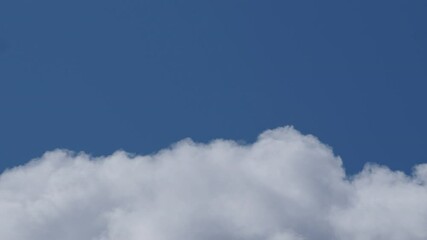 Wall Mural - close-up 4k time lapse video of white big clouds on a blue sunny sky. summer blue cloudy sky time la