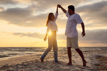 Poster - Happy couple dancing on beach at sunset