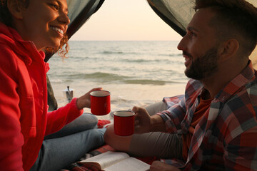 Canvas Print - Couple resting in camping tent near sea