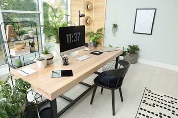 Comfortable workplace with computer in light room. Interior design