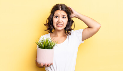 Wall Mural - young hispanic woman feeling stressed, anxious or scared, with hands on head. growth concept