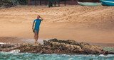 Fototapeta Fototapety z morzem do Twojej sypialni - Mężczyzna surfer idący z deską surfingową tropikalną plażą.