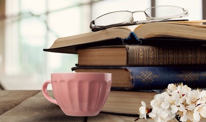 Wall Mural - Spring morning coffee. A cup of coffee, open book on a wooden table