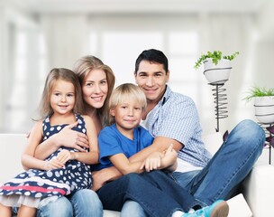 Wall Mural - The happy young family enjoys their free time relaxing together at home.