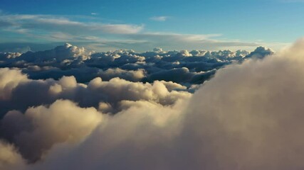 Wall Mural - flying above the clouds. aerial view of clouds at sunrise. traveling by air perfect background, 4k