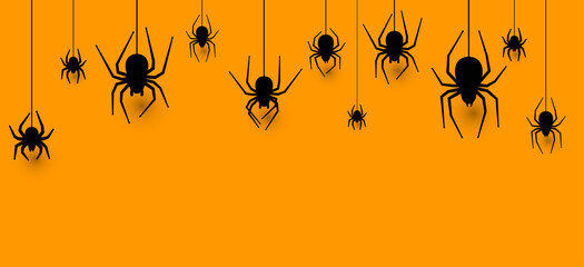 Hanging spiders halloween orange background.