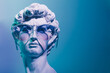 Gypsum copy of the sculpture David Michelangelo in sunglasses on blue background