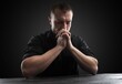 © BillionPhotos.com - man praying to god with hands together praying with dark background
