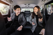 © geargodz - two happy business man and woman talking while sitting at the back seat of car