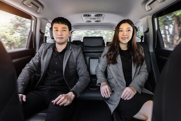 Canvas Print - two business man and woman sitting at the back seat of car