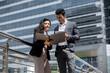 © Atstock Productions - Handsome young Indian businessman in corporate wear talking with businesswoman outdoors in the city