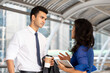 © Atstock Productions - Young handsome Indian businessman talking with female co-worker outdoors in the city