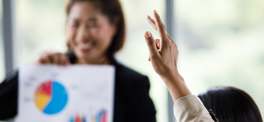 Middle aged happy businesswoman in casual business suit holding showing graph chart diagram paperwork document in hands presenting company target to female colleagues in marketing team meeting room