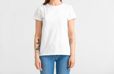 Wall Mural - Young woman in modern t-shirt on white background