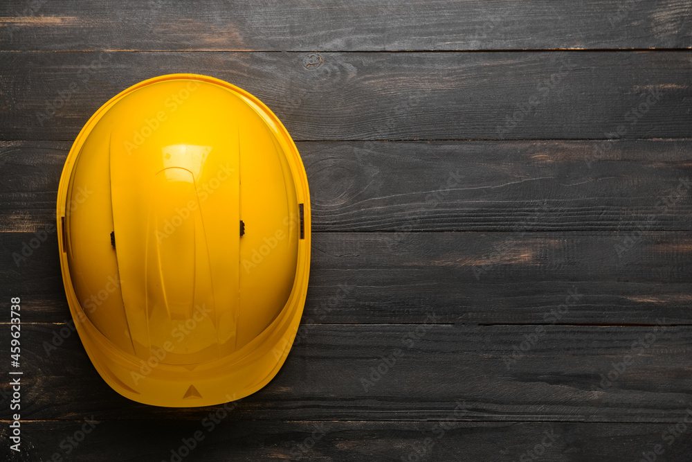 Plastic hardhat on dark wooden background