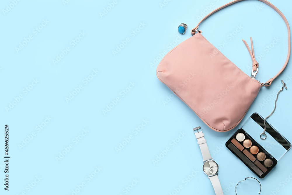 Stylish female accessories and decorative cosmetics on color background