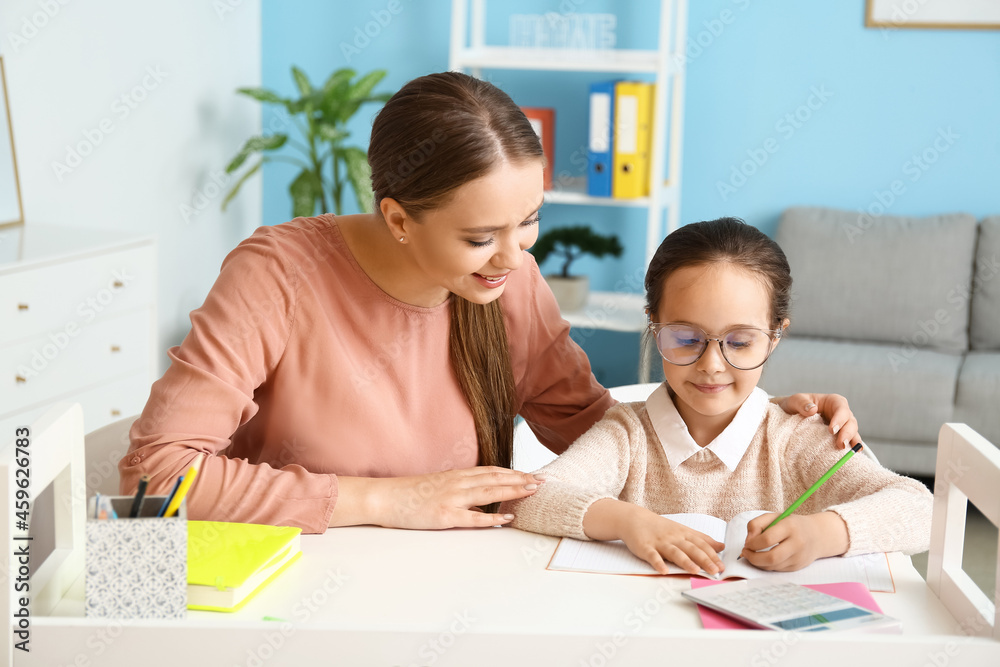 Little girl with her mother doing lessons at home