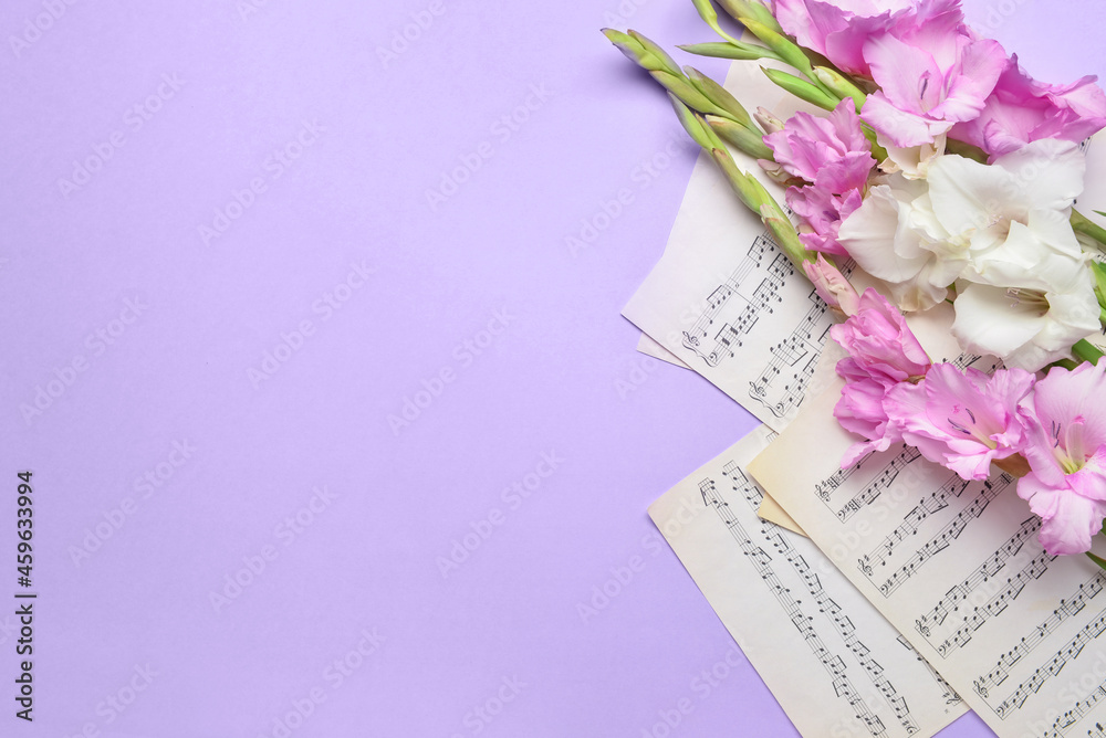 Beautiful gladiolus flowers and note sheets on color background, closeup