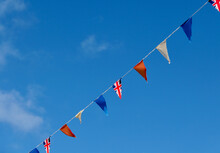 Red, White And Blue Bunting With Union Jack Across Deep Blue Sky