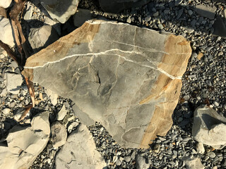 Poster - a large stone lies on a sea pebble on the beach. piece of rock