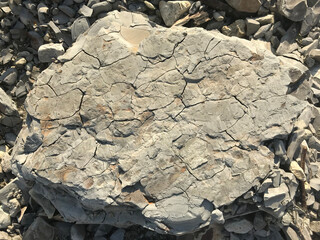 Poster - a large stone lies on a sea pebble on the beach. piece of rock