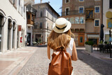 Fototapeta  - Traveler backpacker girl walking in historic city street