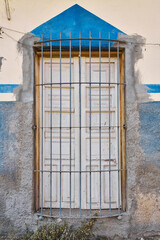 Roughed up and deteriorated facade with very rustic old wooden window