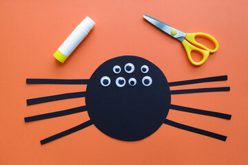 The child creates a black spider decoration. Halloween party. Children's art project. DIY concept. Step-by-step photo instruction. Step 5