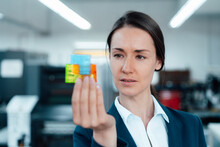 Businesswoman Holding Puzzle Cube In Industry