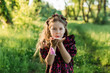 © Westend61 - Playful girl with flower tiara blowing peony petal