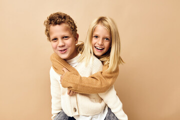 boy and girl together in sweaters fun casual wear beige background