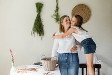 Girl Embracing Mother At Home
