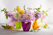 Autumn Still Life With Bouquets Of Flowers In Multicolored Vases On Table. Autumn Floral Decoration For Home.