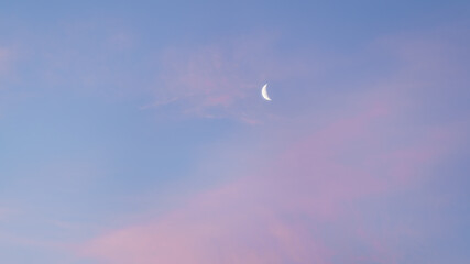 the dawn sky with a crescent moon, with pink and blue shades. beautiful natural background before su