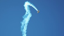 Small Retro Airplane, Light Aircraft Flying In Blue Sky And Doing Stunts