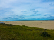 Panorama View Of Dunes With Marram Grass And An Empty Beach On The Dutch Island Of Texel On A  With A Blue Cloudy Sky In Summer. National Park Duinen Van Texel  Tourism And Vacations Concept.	
